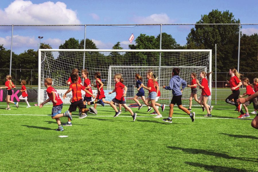 Kinderen van De Sportanen rennen samen over het sportveld